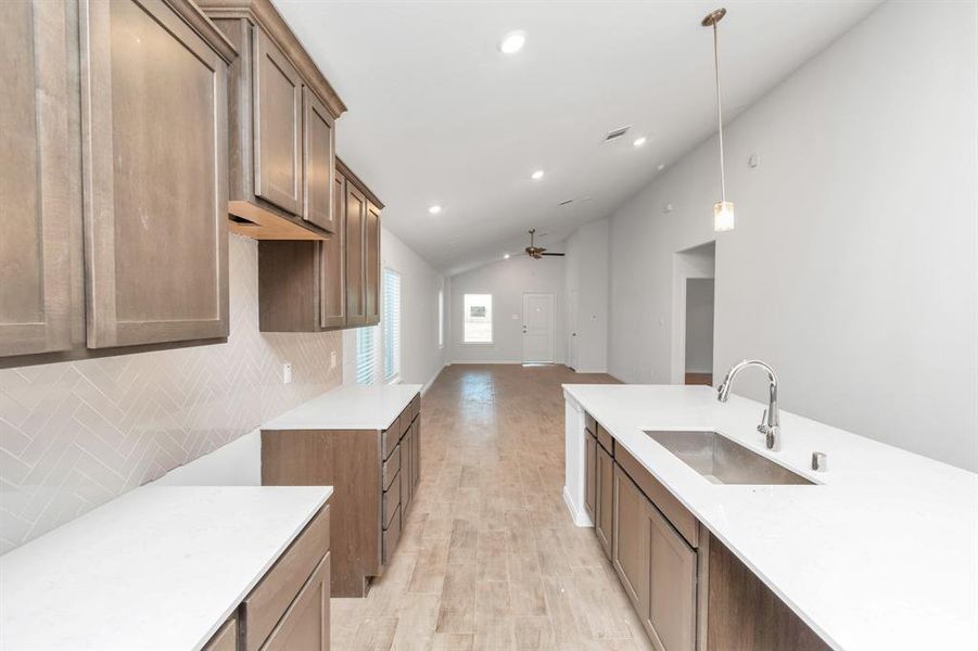 Modern meets functionality in this sleek kitchen. The oversized island provides ample space for meal preparation or casual dining, while pendant lighting adds a touch of elegance. **This image is from another Saratoga Home - Clover floorplan.**