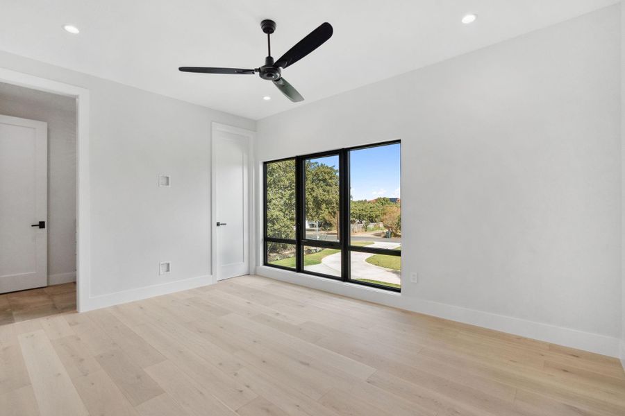 Bright and airy third bedroom with generous closet space, connected to a Jack-and-Jill bathroom featuring individual vanities and a shared shower.