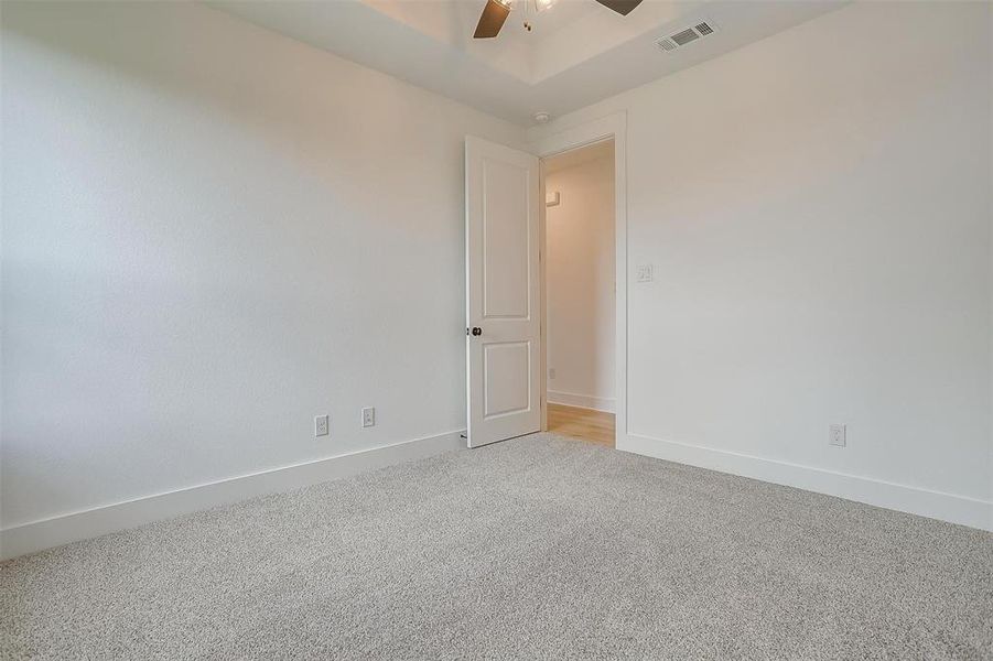 Carpeted empty room featuring ceiling fan