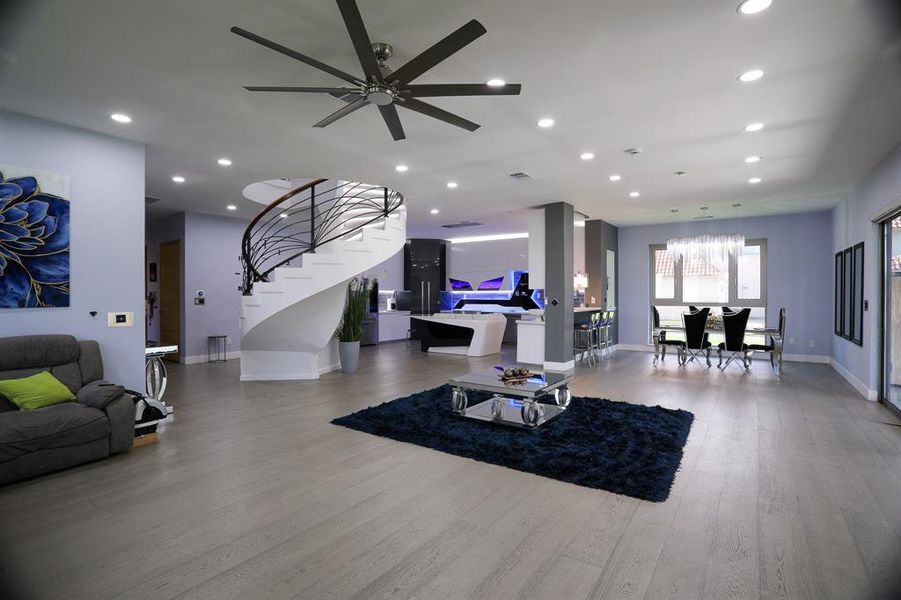 Living room with ceiling fan and hardwood / wood-style floors