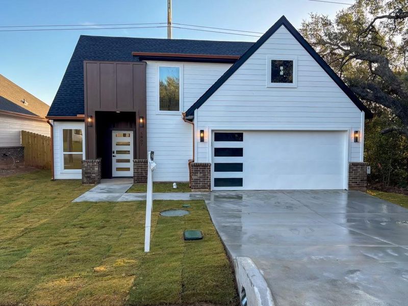 View of front of property with a front lawn and a garage