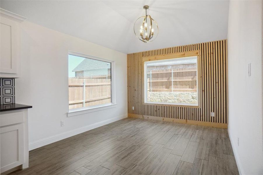 Unfurnished dining area with hardwood / wood-style flooring and a chandelier