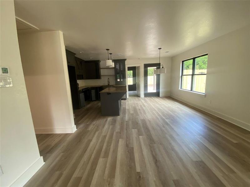 Kitchen with hanging light fixtures, a kitchen island, a breakfast bar area, dark hardwood / wood-style floors, and sink