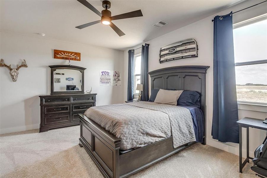 Carpeted bedroom featuring ceiling fan