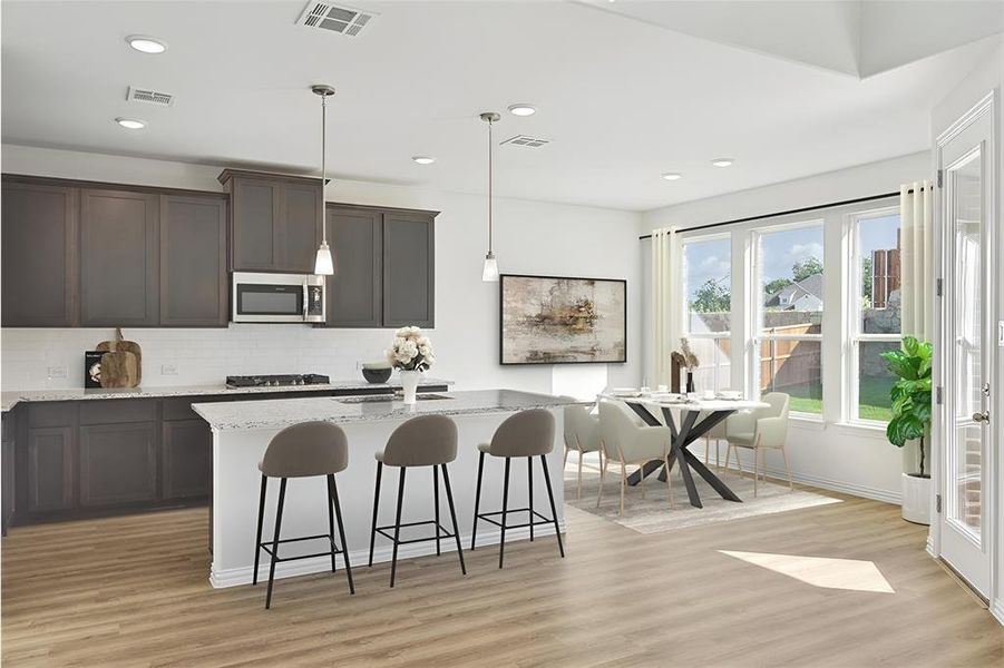 Kitchen featuring light stone counters, tasteful backsplash, light wood-type flooring, gas stovetop, and decorative light fixtures