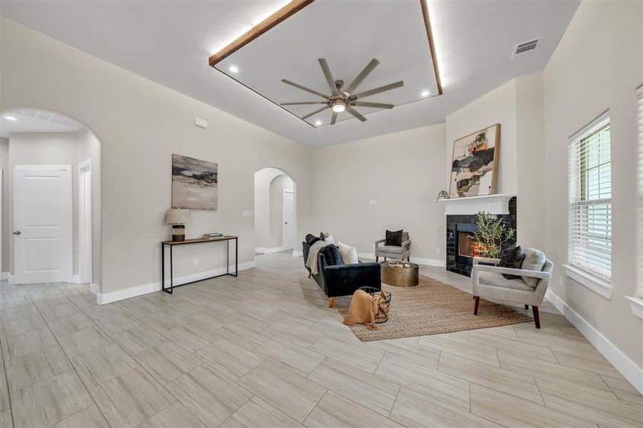 Tiled living room featuring a tile fireplace and ceiling fan