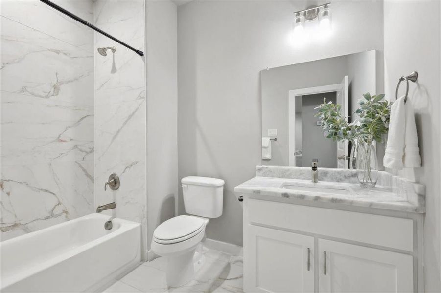 Full bathroom with vanity, toilet, and tiled shower / bath combo