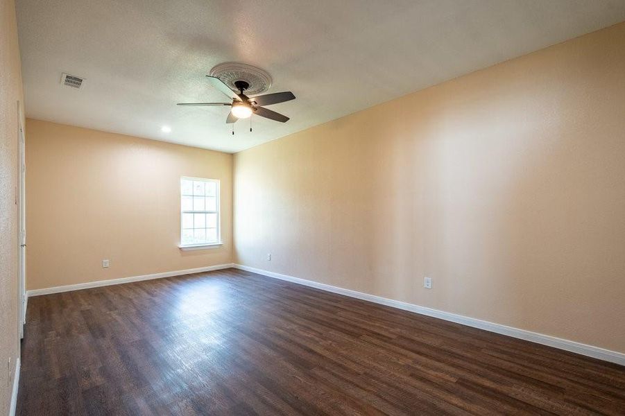 Unfurnished room featuring ceiling fan and dark hardwood / wood-style floors