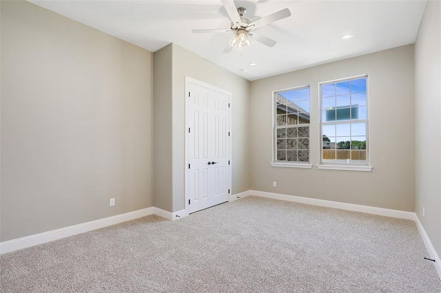 Spare room featuring carpet and ceiling fan