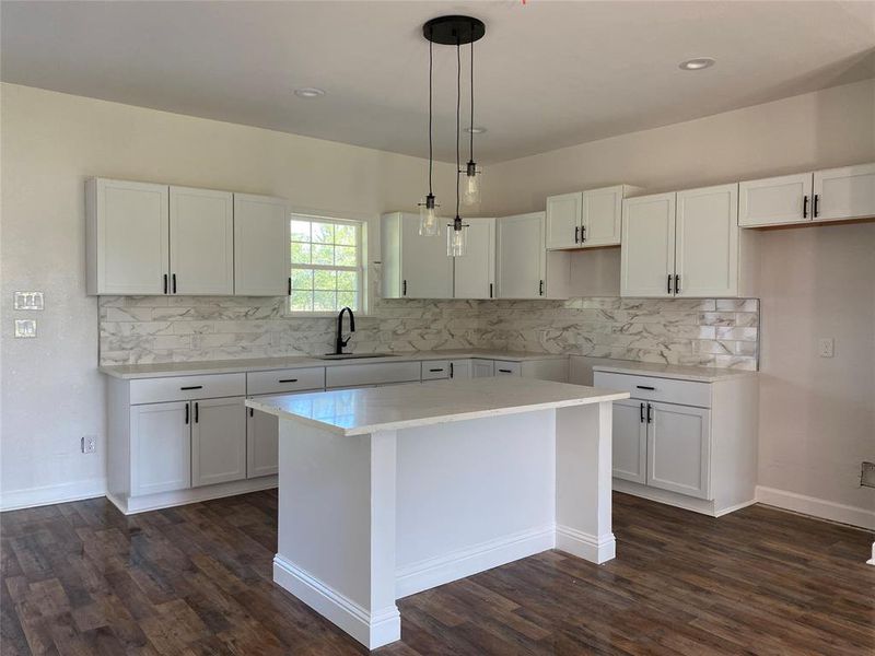 Kitchen featuring sink, white cabinetry, dark hardwood / wood-style floors, and backsplash
