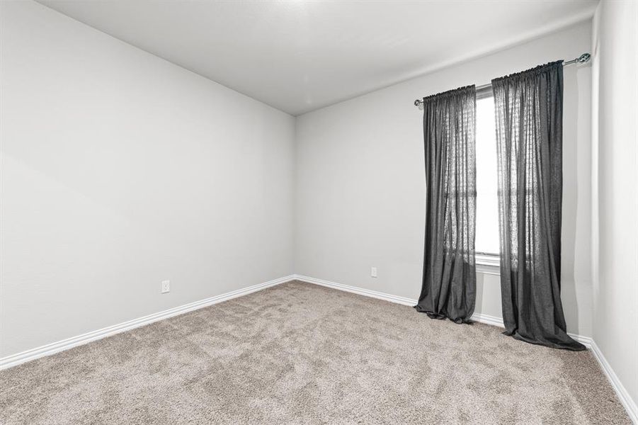 Unfurnished room featuring a wealth of natural light and light carpet