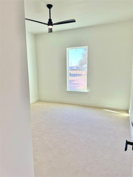 Carpeted spare room with ceiling fan