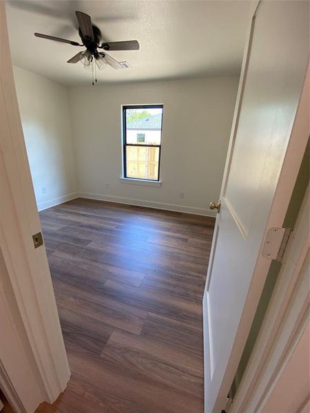 Spare room featuring dark hardwood / wood-style flooring and ceiling fan