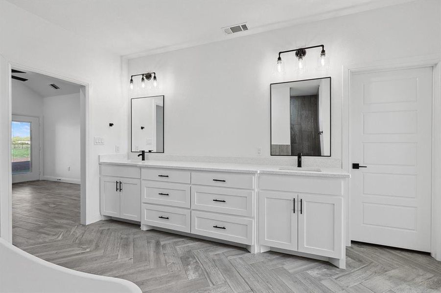 Bathroom with ceiling fan, a washtub, vanity, parquet flooring, and vaulted ceiling