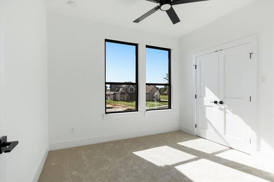 Carpeted spare room with ceiling fan