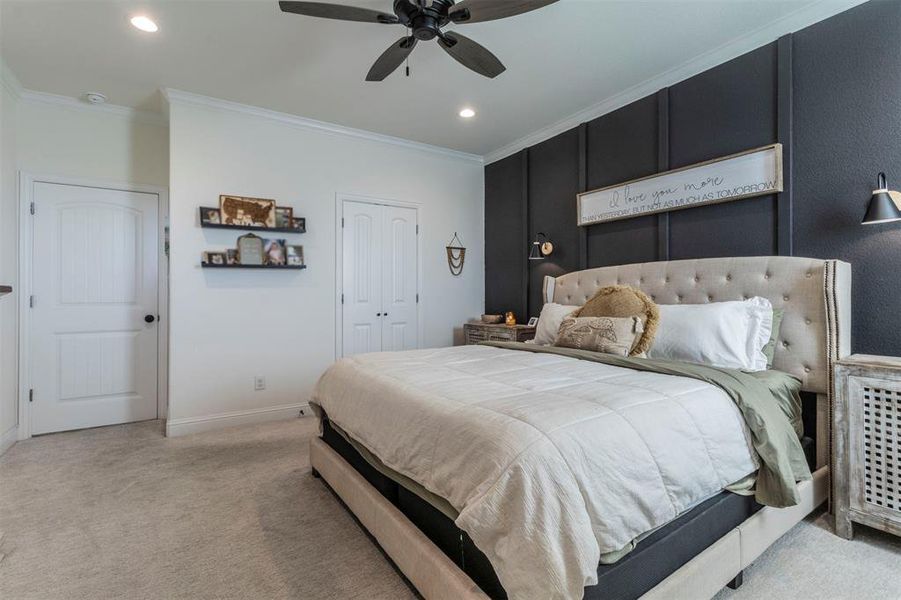 Carpeted bedroom featuring a En-suite bathroom, ceiling fan, and crown molding