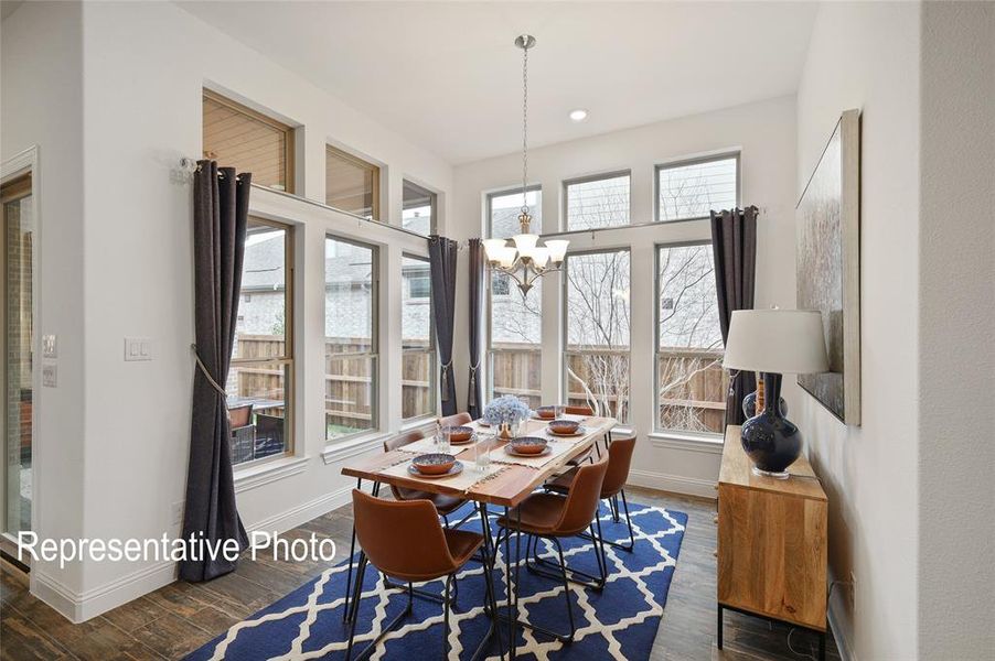 Dining area featuring an inviting chandelier and dark wood-type flooring