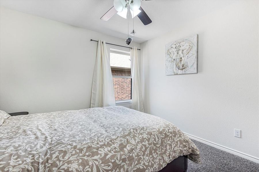 Carpeted bedroom featuring ceiling fan