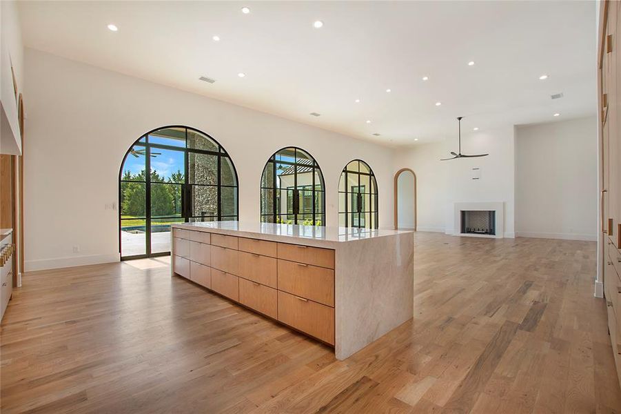 Kitchen featuring ceiling fan, light brown cabinets, light wood-type flooring, and a kitchen island