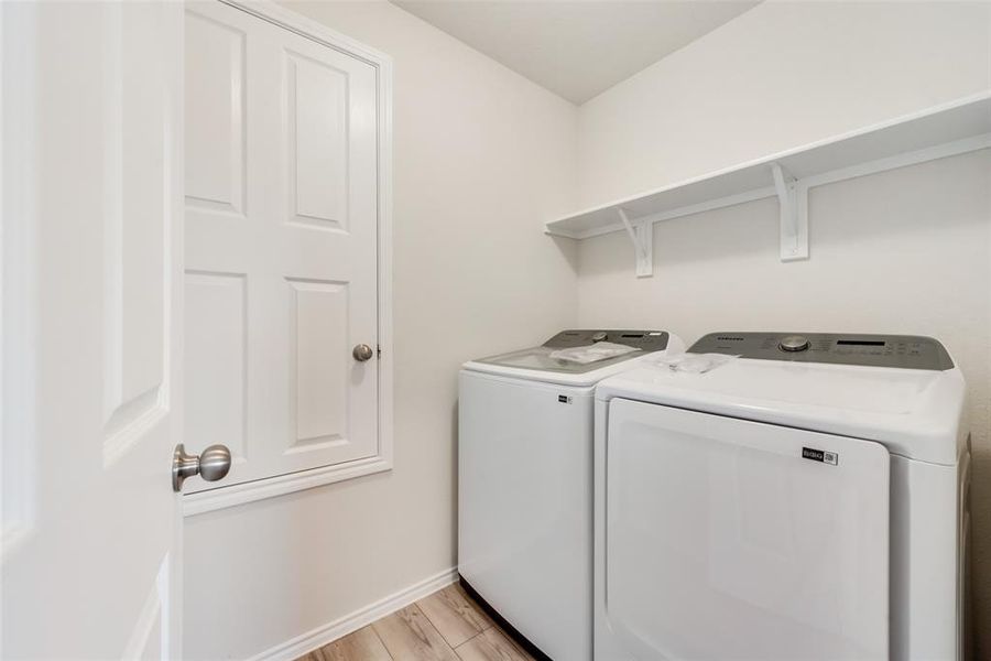 Laundry area with LVP floors and a useful shelf