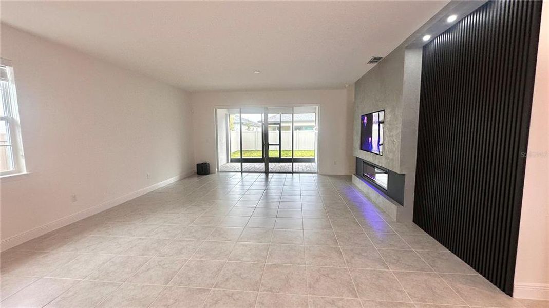 Textured wall with built in 65" TV , hidden surround sound system and accent wooden wall