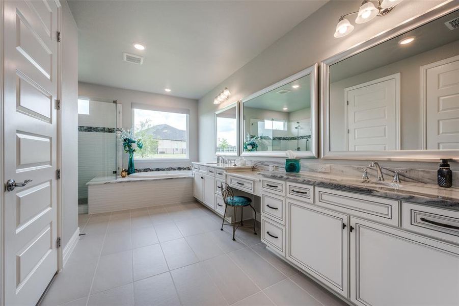 Primary Bathroom with vanity, separate shower and tub, Dolomite countertops and tile flooring