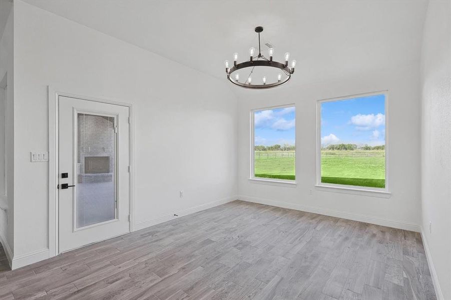 Unfurnished dining area with a chandelier and light hardwood / wood-style flooring