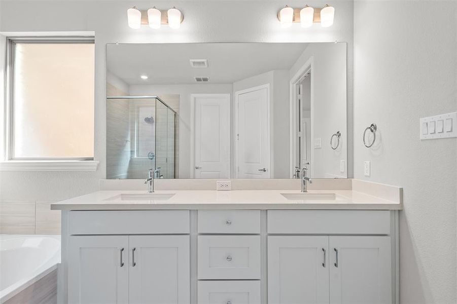 Bathroom featuring vanity and shower with separate bathtub