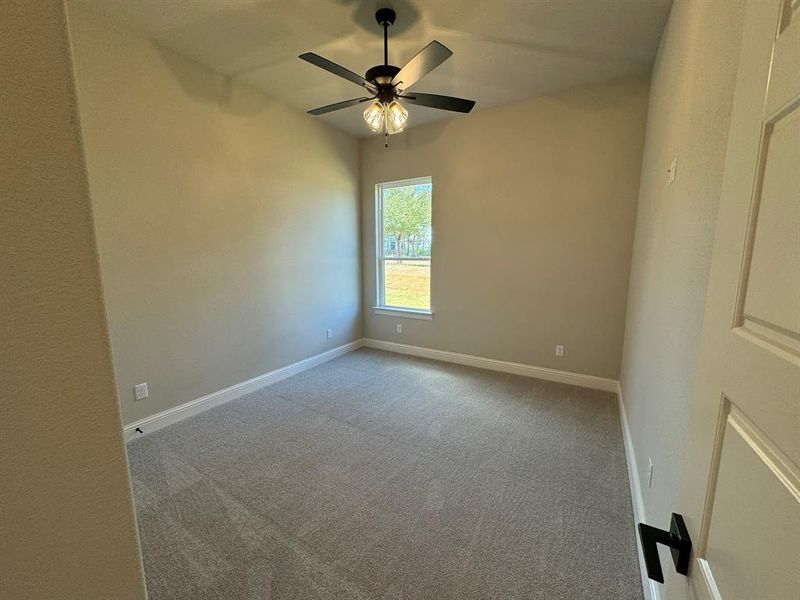 Carpeted spare room with ceiling fan