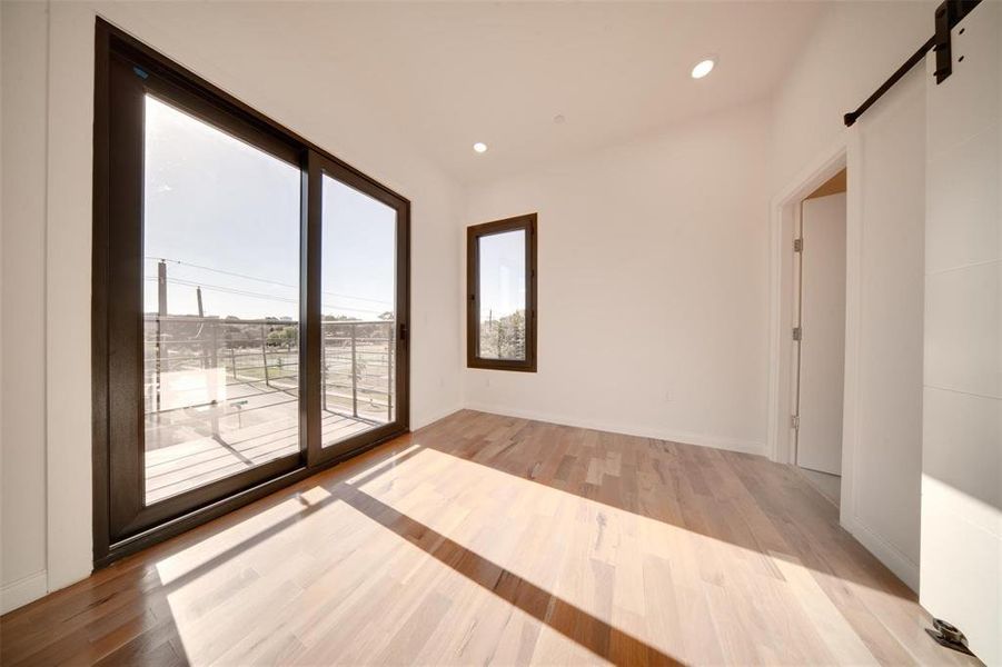 Empty room featuring light hardwood / wood-style flooring and a barn door