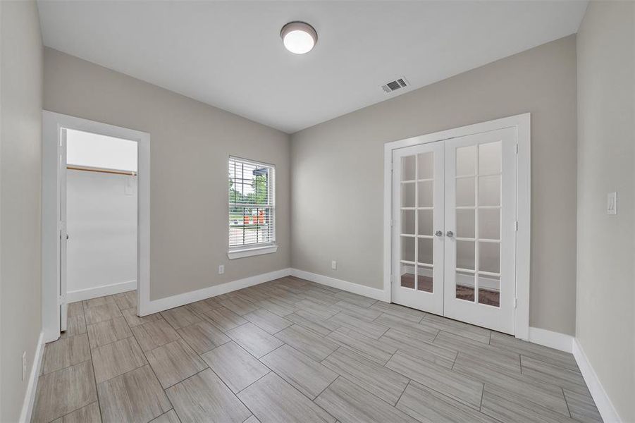 Unfurnished room featuring french doors and light tile patterned floors