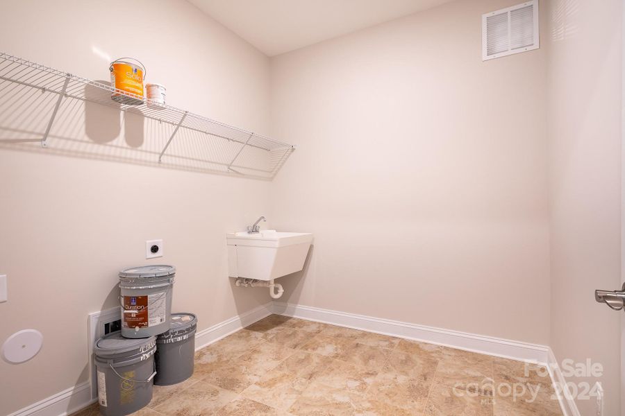 The generously sized Laundry Room boasts tiled floors, a free-standing Laundry Tub w/convenient placement on the main level, ensuring both practicality & ease of use.