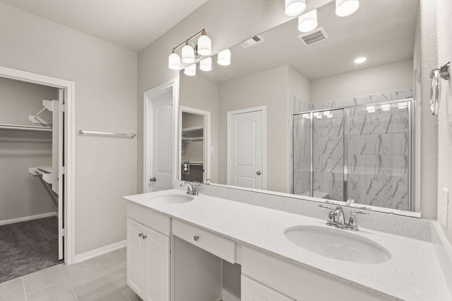 The primary bath features a large double sink vanity and leads to the oversized primary walk-in closet.