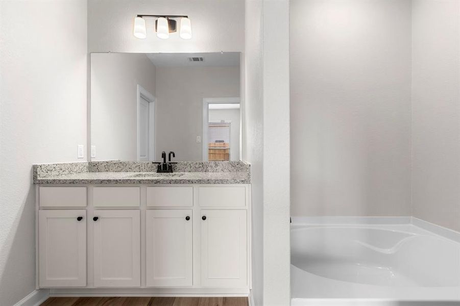 The primary bathroom features a soaking tub and spearate tiled shower.