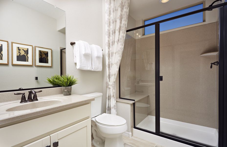 Guest bathroom features a shower with a seat