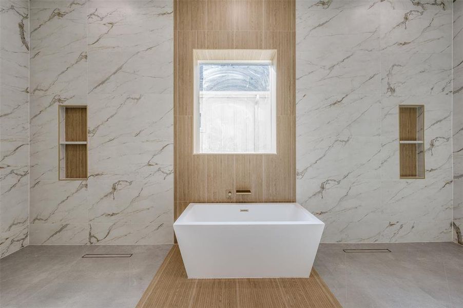 Bathroom featuring shower with separate bathtub and tile walls