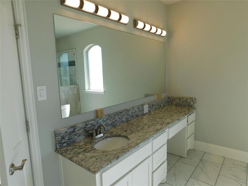 Primary bathroom with separate vanities.