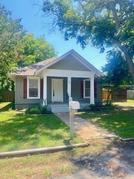 View of front of property with a porch and a front yard