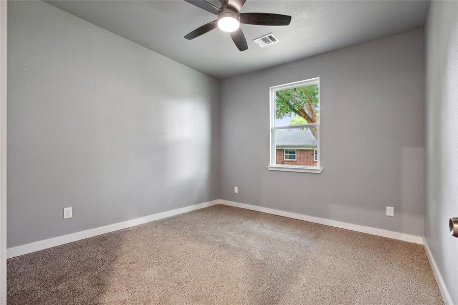 Carpeted empty room featuring ceiling fan