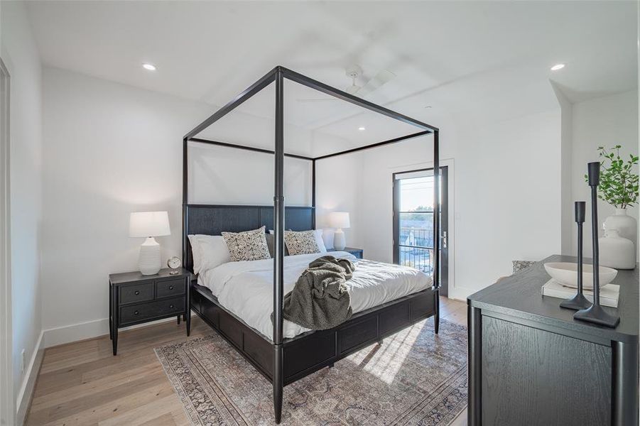 Primary bedroom with light wood flooring