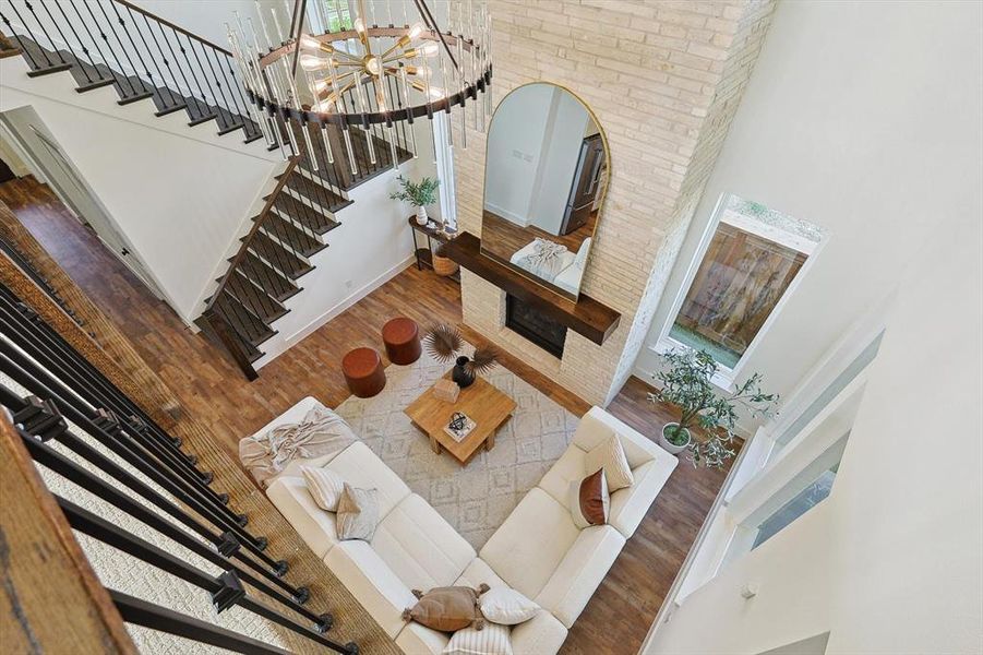 Living room with a high ceiling, wood-type flooring, and a chandelier