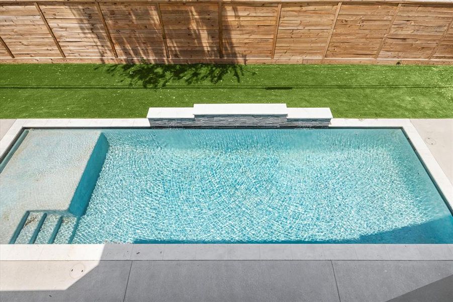 This stunning gunite pool features a tanning ledge, ideal for setting up chairs that let you relax in the water while soaking up the sun