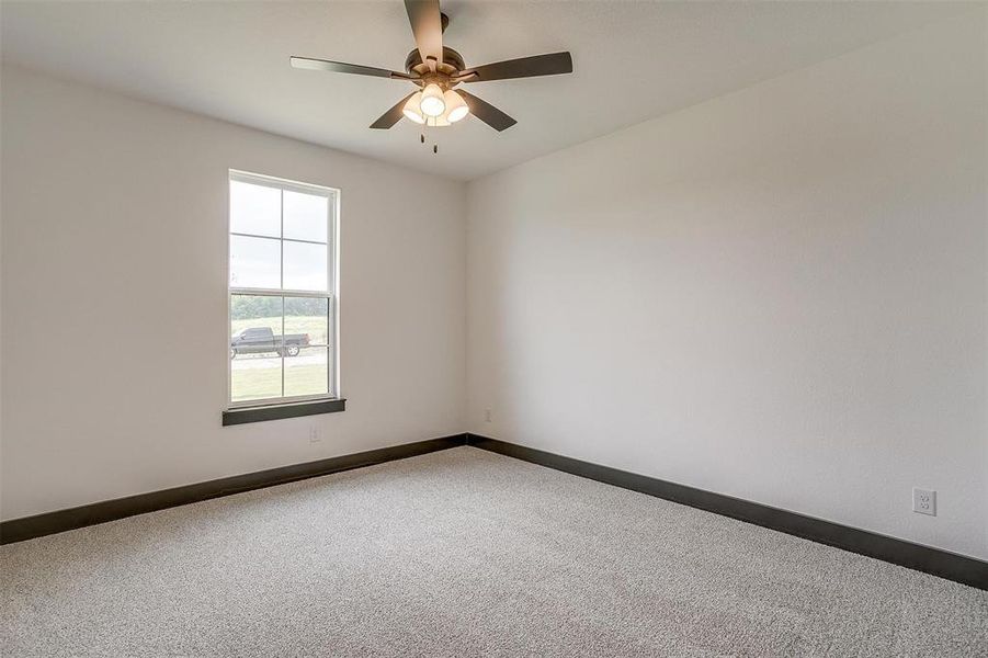 Carpeted empty room with ceiling fan