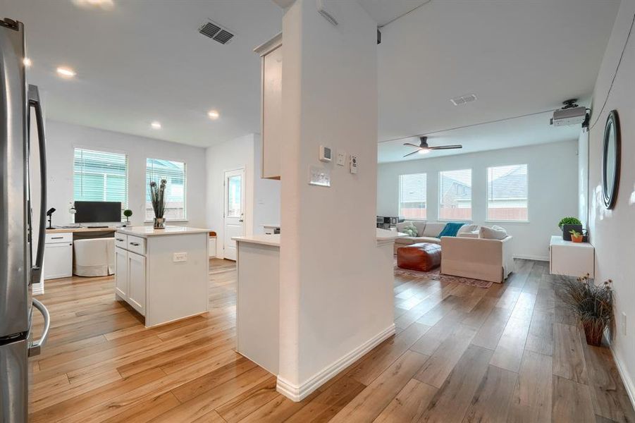 Kitchen with white cabinetry, a wealth of natural light, light hardwood / wood-style flooring, and a kitchen island