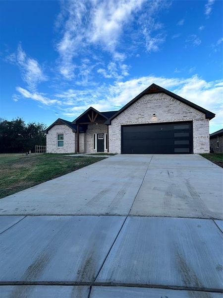 Ranch-style home with a front yard and a garage