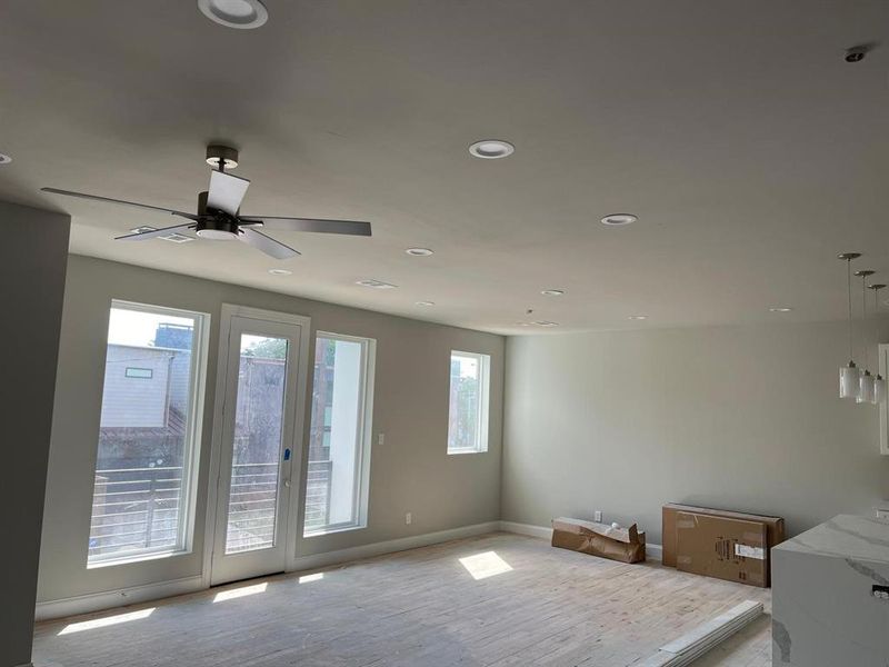 Unfurnished room featuring plenty of natural light, ceiling fan, and light hardwood / wood-style flooring