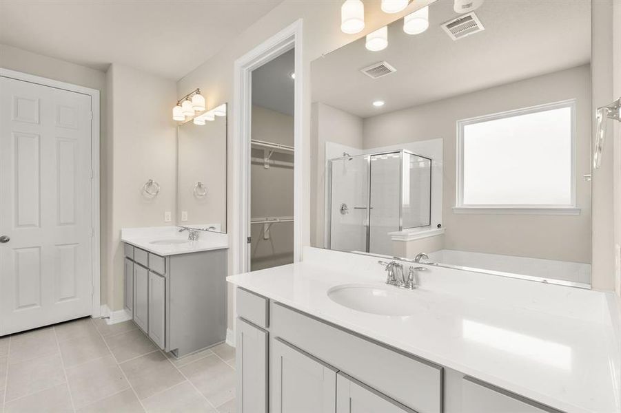 The en-suite bathroom offers a spa-like atmosphere with its elegant design, high end finishes, and tasteful lighting, creating a retreat within your own home.