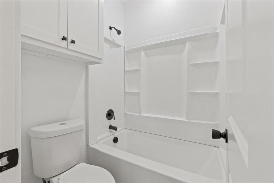 Bathroom featuring bathing tub / shower combination and toilet