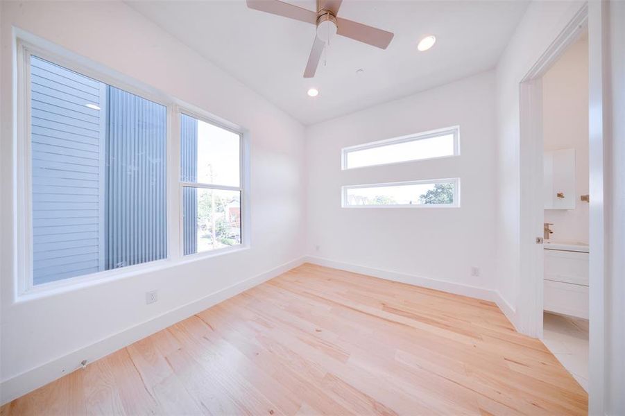 Empty room with ceiling fan and light wood-type flooring