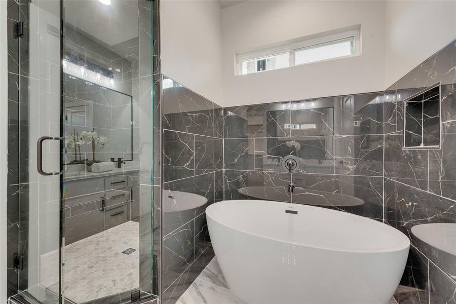 Bathroom featuring shower with separate bathtub, tile patterned floors, and tile walls